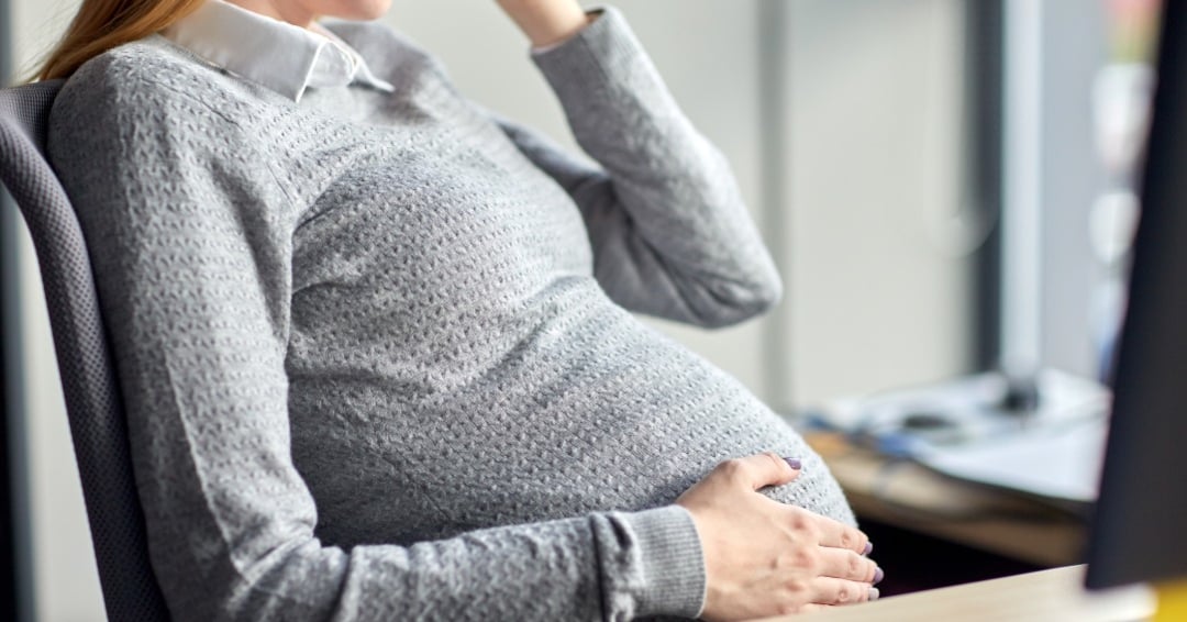 Pregnancy, business, work and people concept - pregnant businesswoman sitting at office